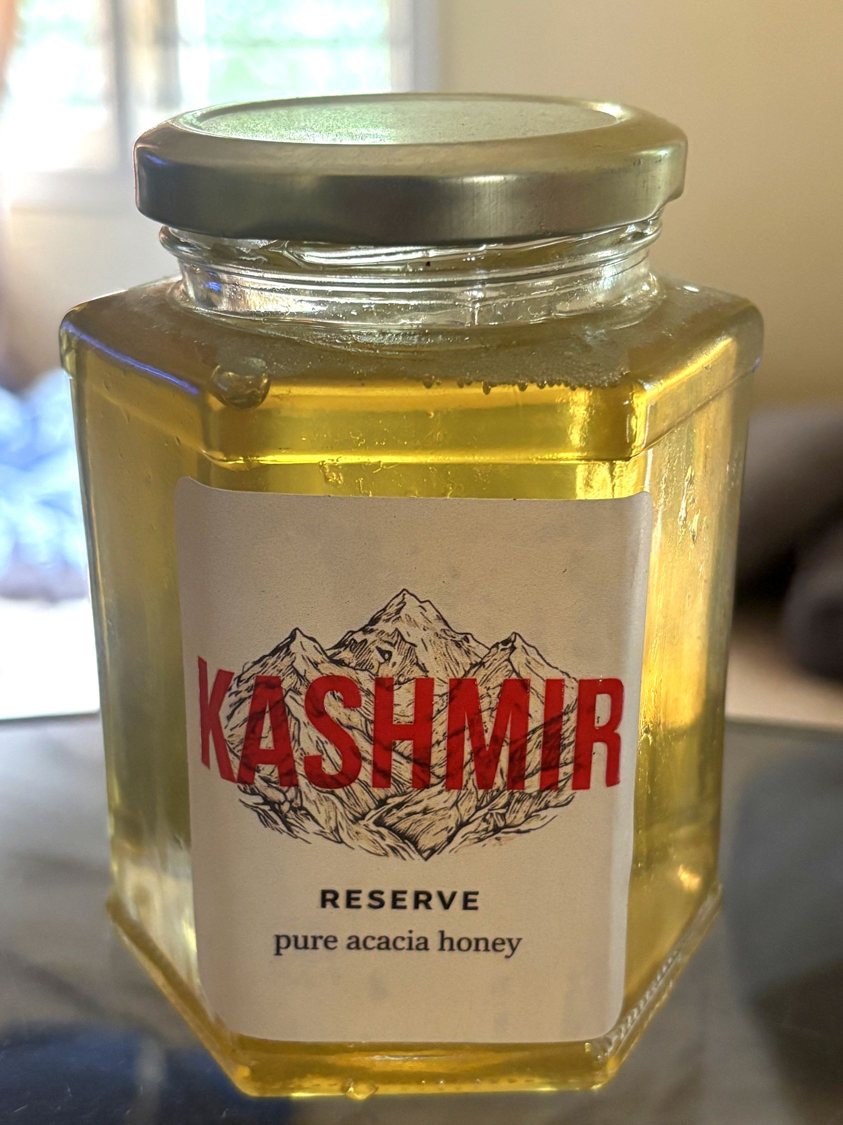 Kashmir Reserve pure acacia honey, real jar backlit in natural light