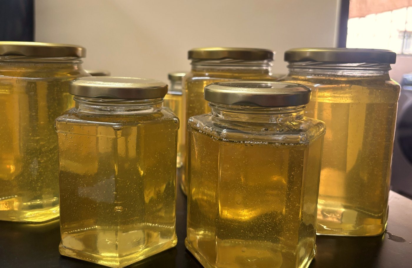 Filled glass jars of Kashmir Reserve acacia honey before labelling